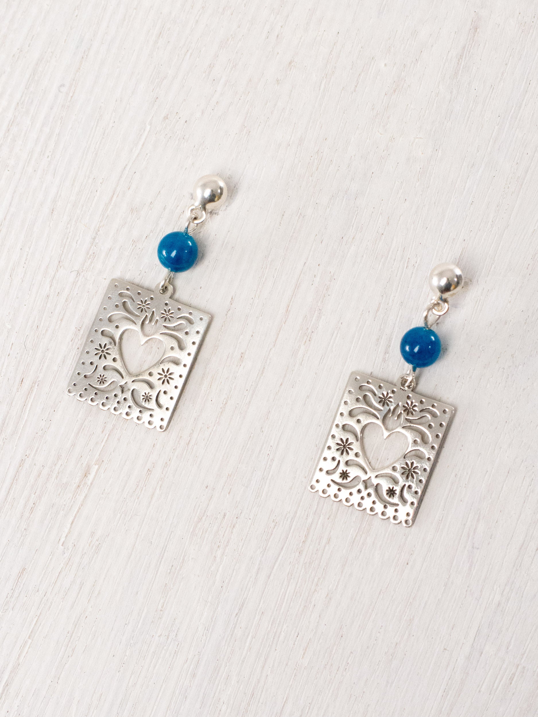 Cut-paper earrings with a heart and stones at the top