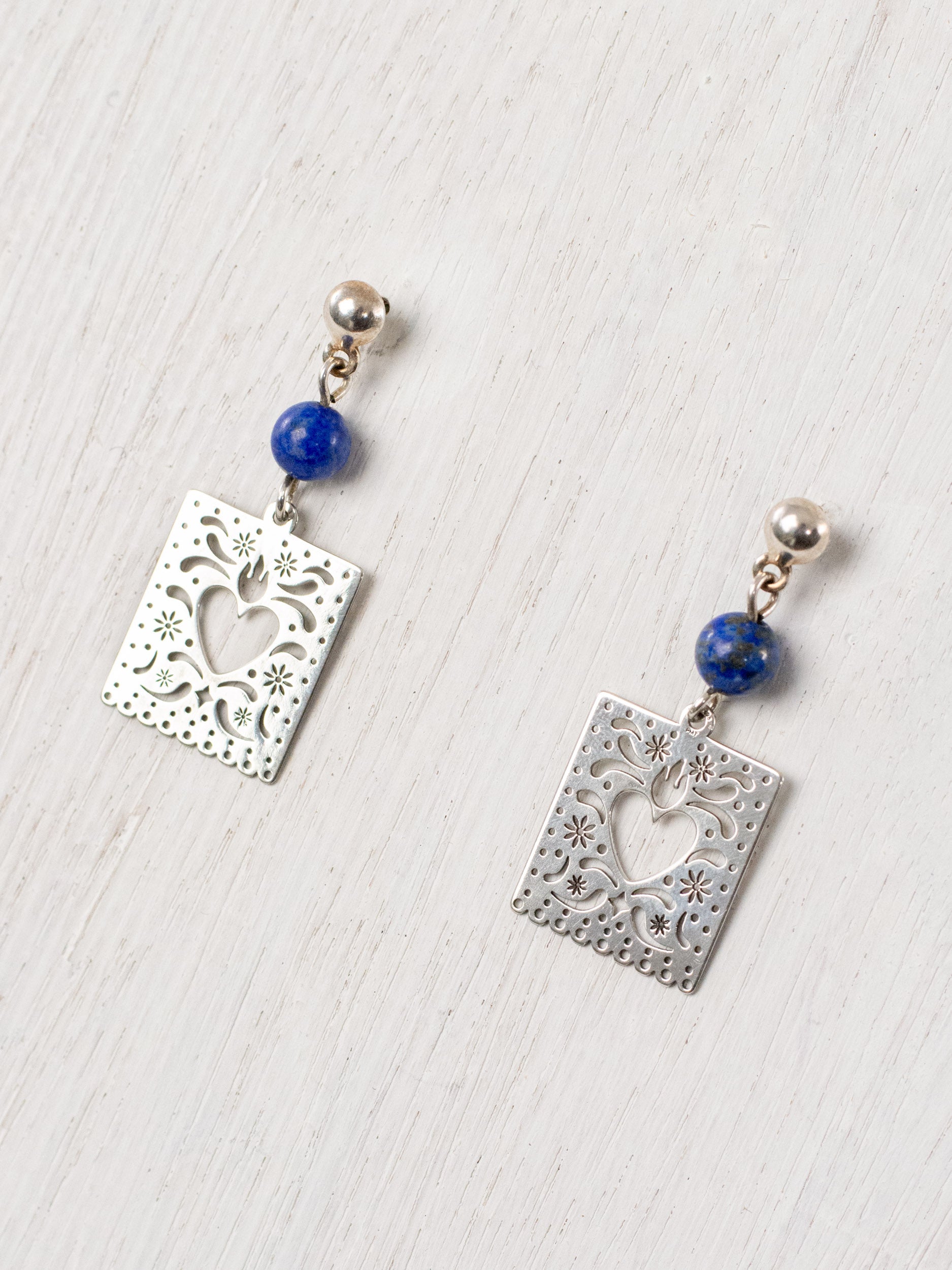 Cut-paper earrings with a heart and stones at the top